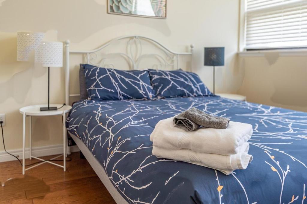 a bedroom with a blue bed with towels on it at Sunny Downtown Loft with AC, Unit #2 in Halifax