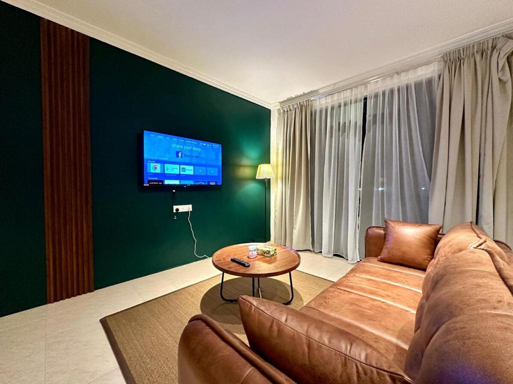 a living room with a couch and a table at BNB Cozy Homestay - Cyberjaya, 14 pax in Cyberjaya