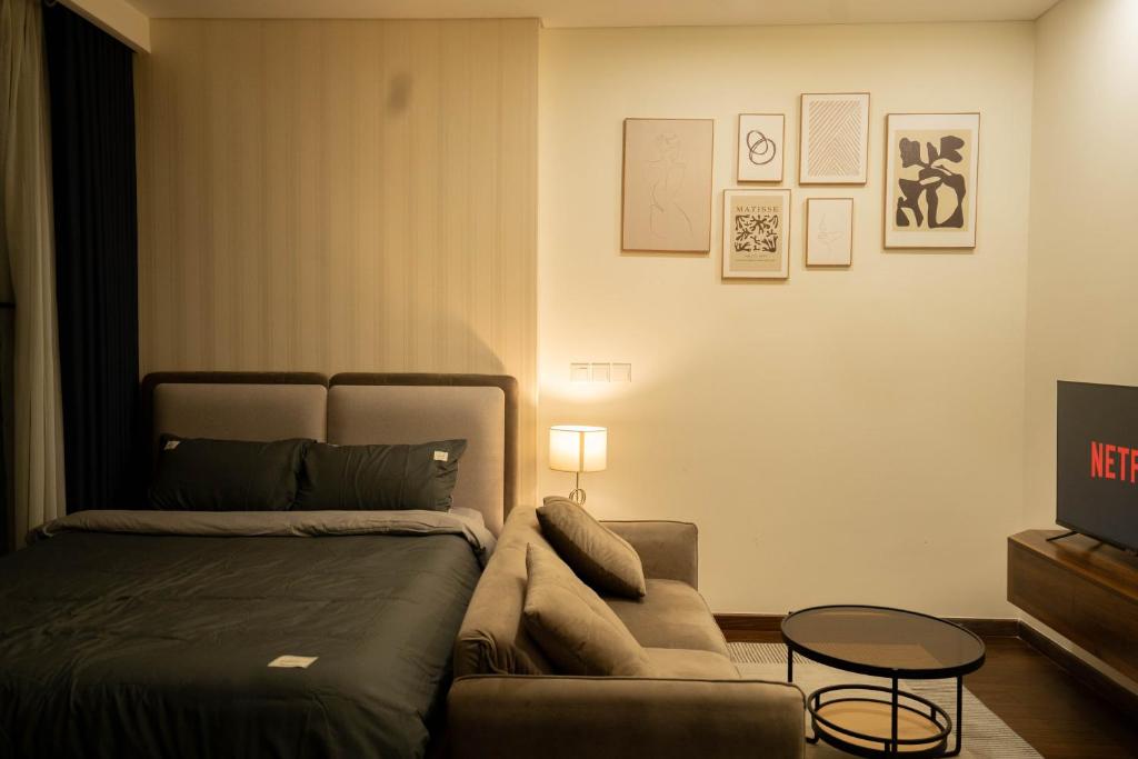 Nam Tu LiemにあるỞ Nhà Apartment Vinhomes Smart Cityのベッドとソファとテーブルのある寝室