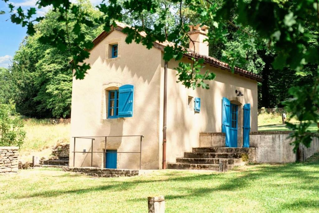 stary dom z niebieskimi drzwiami na polu w obiekcie Petite maison charmante à Cons-la-Grandville avec terrasse et jardin w mieście Cons-la-Grandville