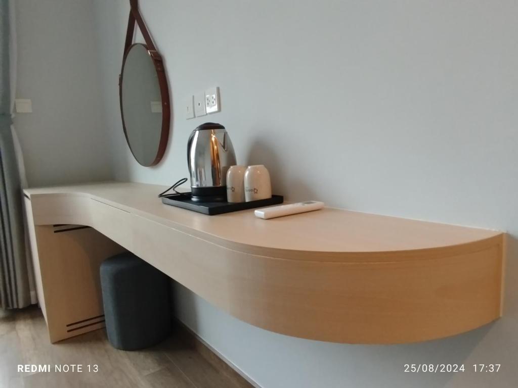 a bathroom counter with a mirror and a sink at Queen HT Phú Quốc in Phu Quoc