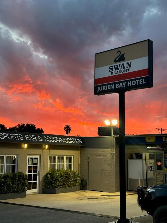 a sign in front of a hotel with a sunset at Jurien Bay Hotel Motel in Jurien Bay