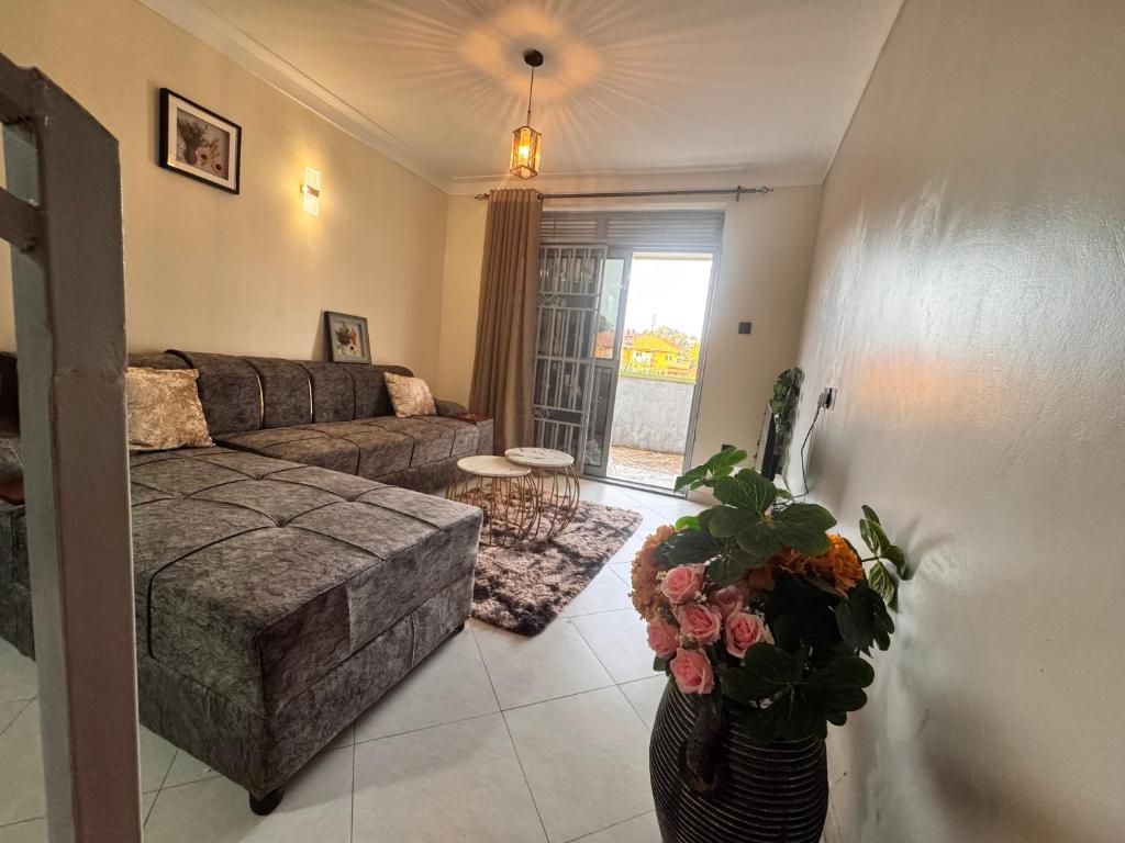 a living room with a couch and a vase with flowers at Fatisa homes in Kampala