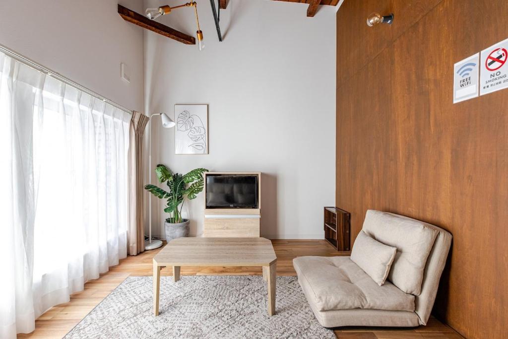 a living room with a couch and a coffee table at SSr大和町1丁目 in Tokyo