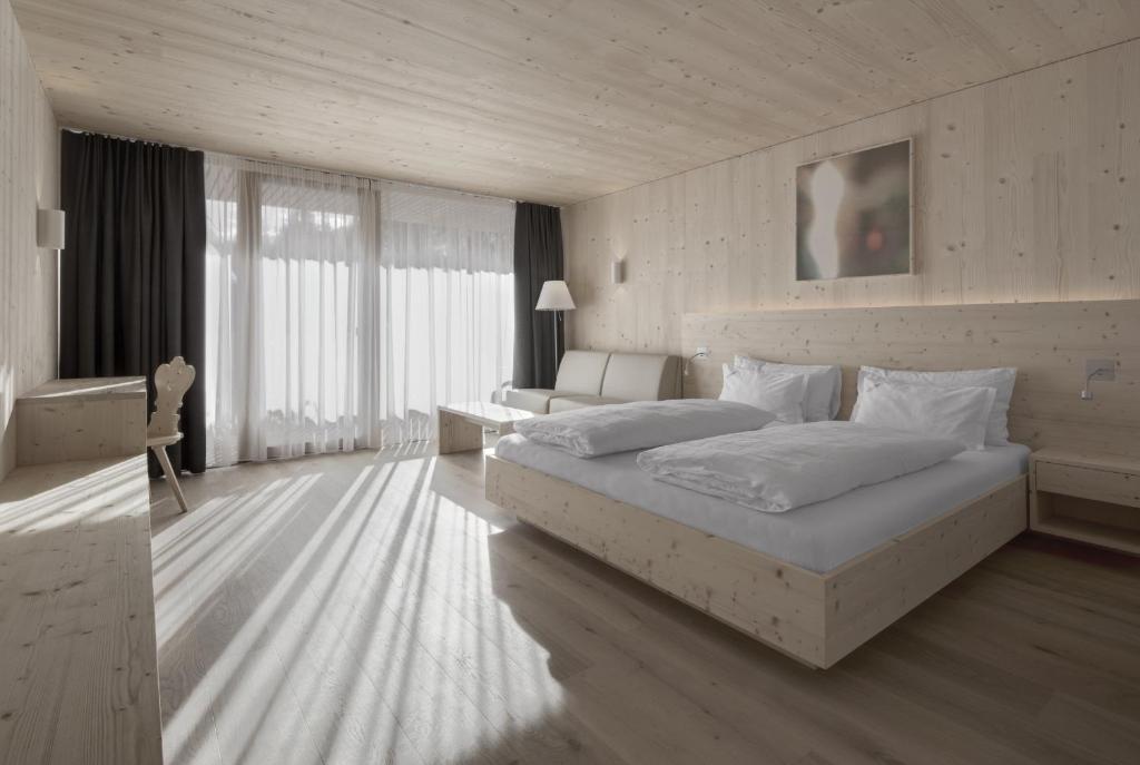 Habitación de hotel con cama, escritorio y cama sidx sidx sidx sidx sidx sidx sidx en Hotel Gardenazza, en Badia