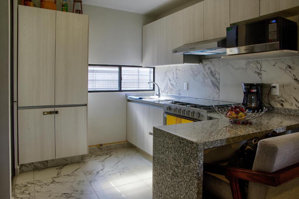 a kitchen with white cabinets and a counter top at Casa Moderna con Alberca en Morelos in Xochitepec