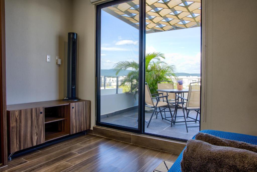 a living room with a large sliding glass door with a balcony at Casa Moderna con Alberca en Morelos in Xochitepec