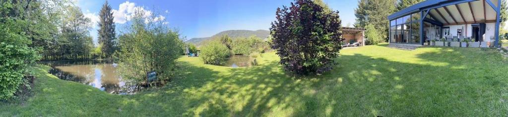un grand jardin avec un bâtiment, des arbres et de l'herbe dans l'établissement la Heckeliere, à La Houssière