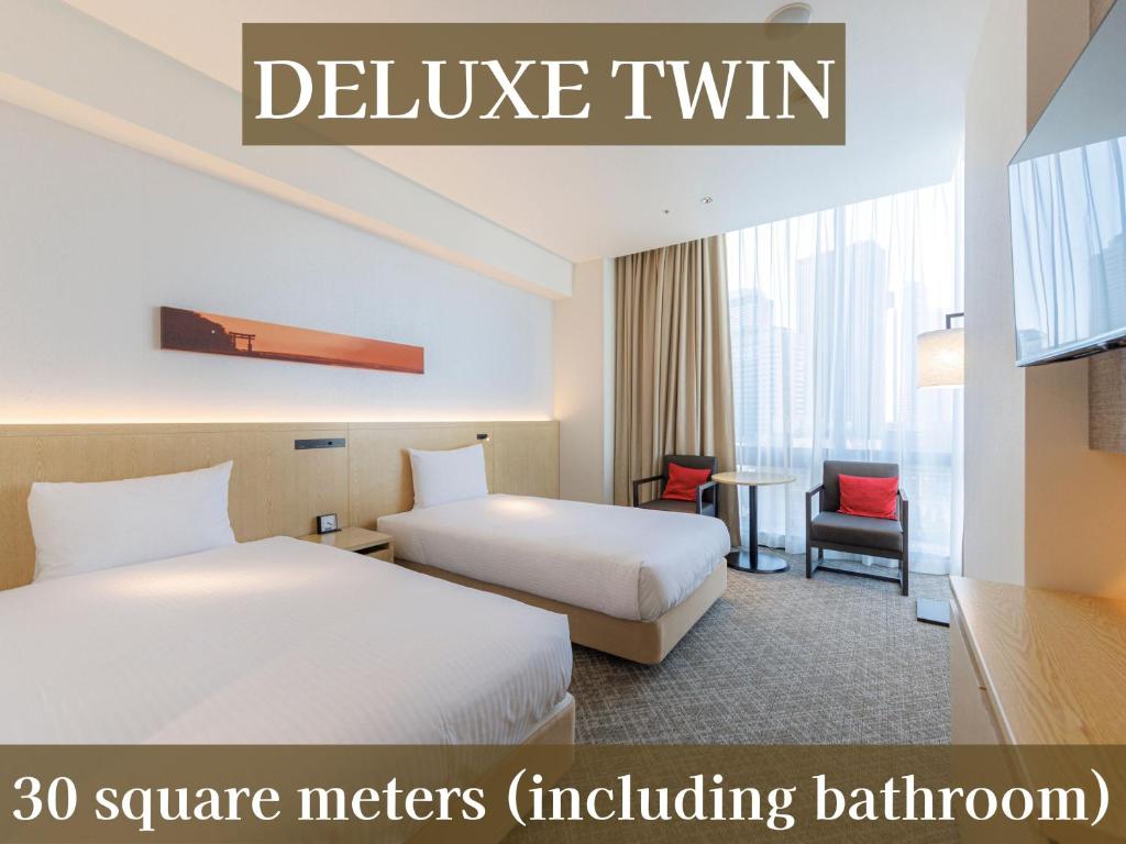 a hotel room with two beds and a tv at JR Kyushu Hotel Blossom Shinjuku in Tokyo