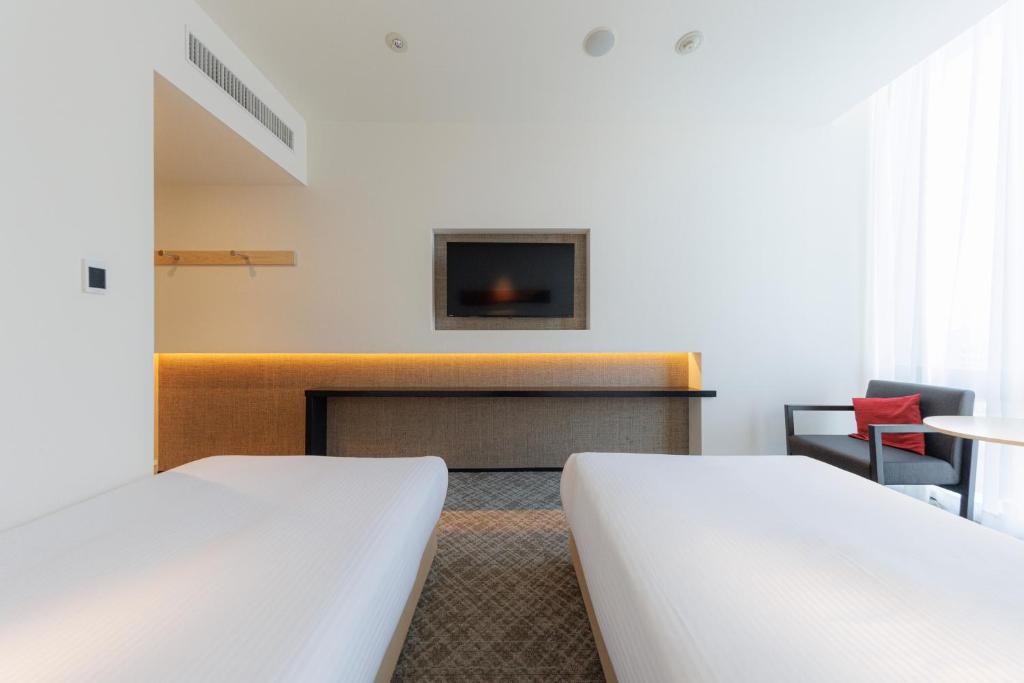 a hotel room with two beds and a fireplace at JR Kyushu Hotel Blossom Shinjuku in Tokyo