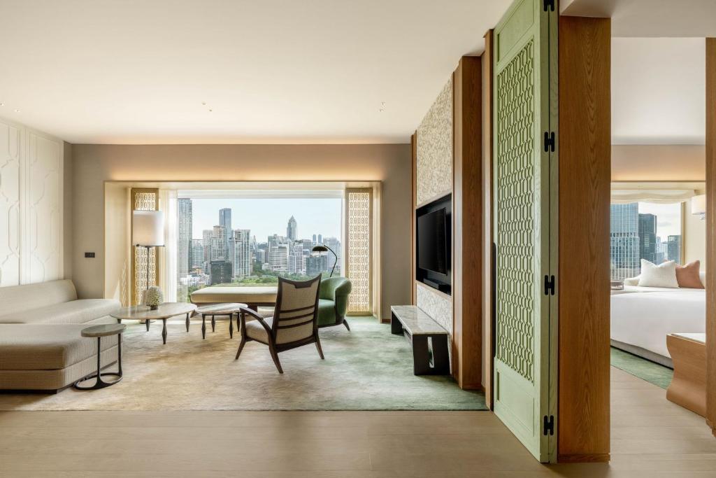 A wide view across a sitting room toward the skyline, with a partially visible separate sleeping area.