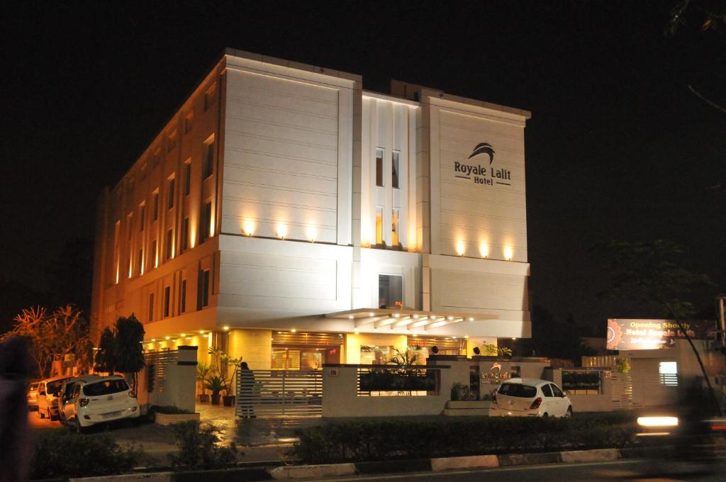 un edificio con auto parcheggiate di fronte ad esso di notte di Royale Lalit Hotel Jaipur a Jaipur