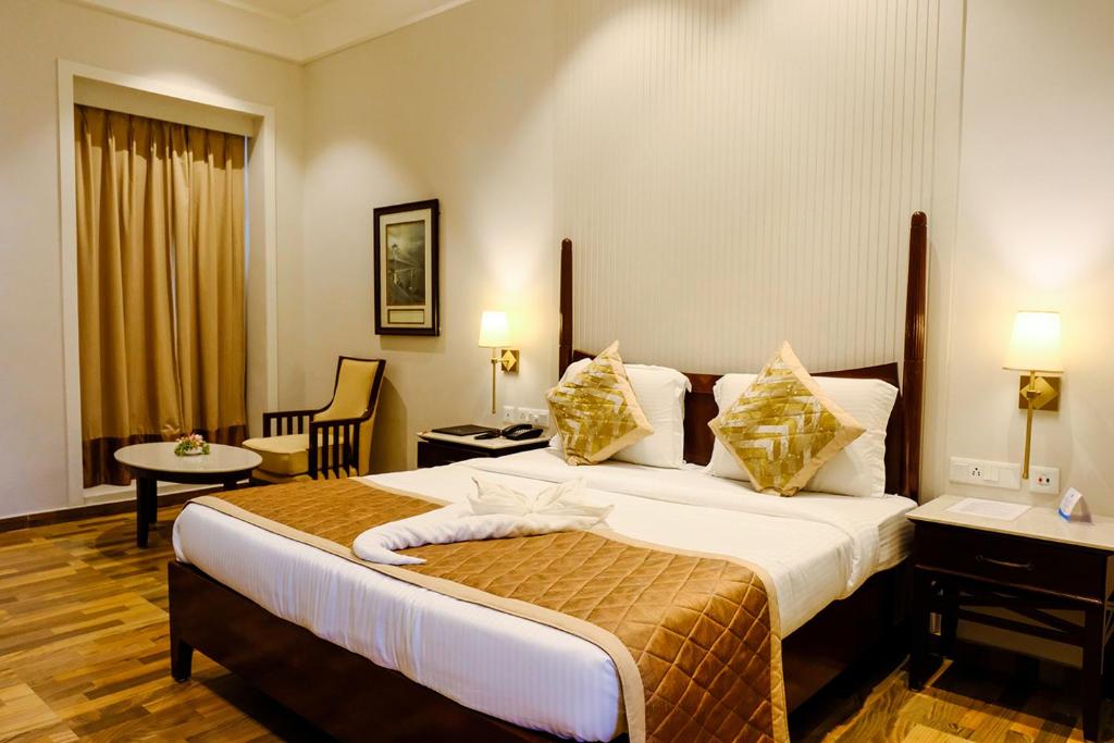 Postel nebo postele na pokoji v ubytování Chanakya BNR Hotel