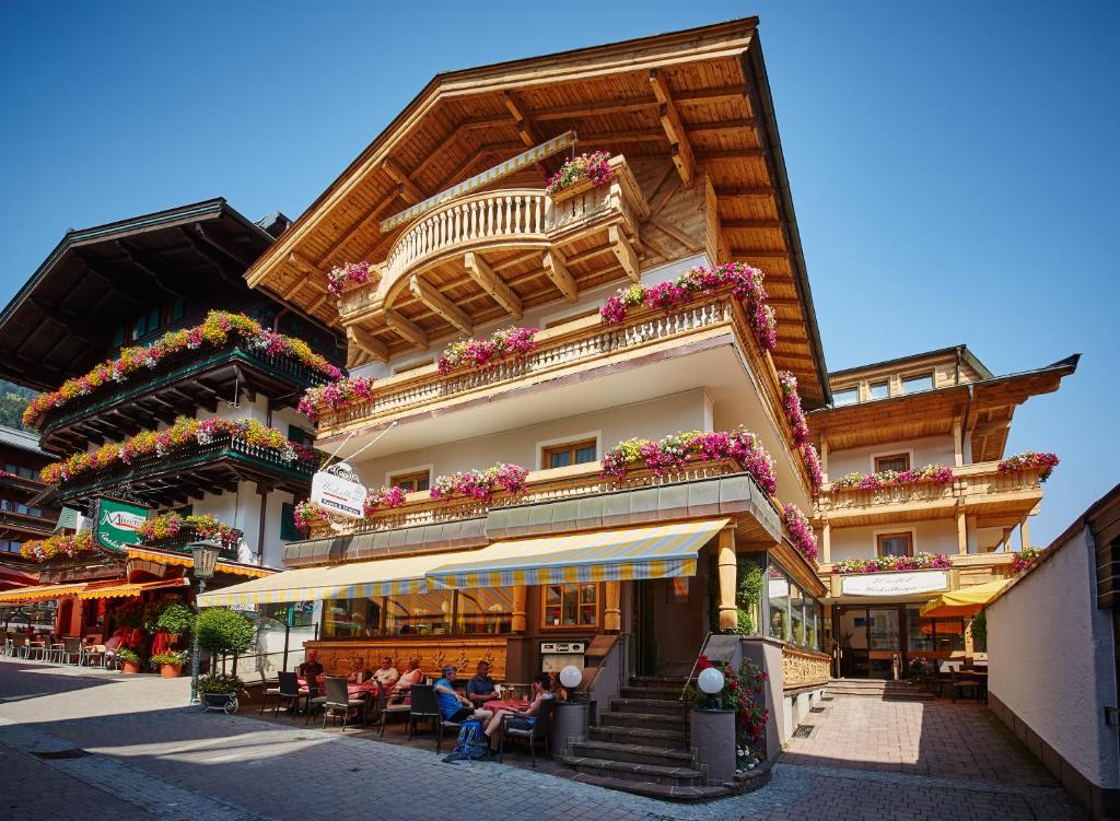 Ein Gebäude mit Leuten, die draußen sitzen. in der Unterkunft Hotel Wechselberger in Saalbach-Hinterglemm