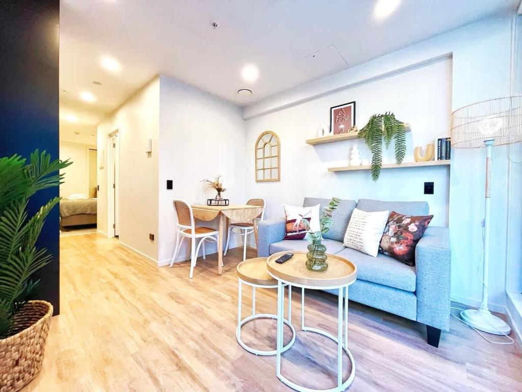 a living room with a blue couch and a table at Serene Cityscape 1B Apt Near Skytower vs Gym Pool Sauna in Auckland