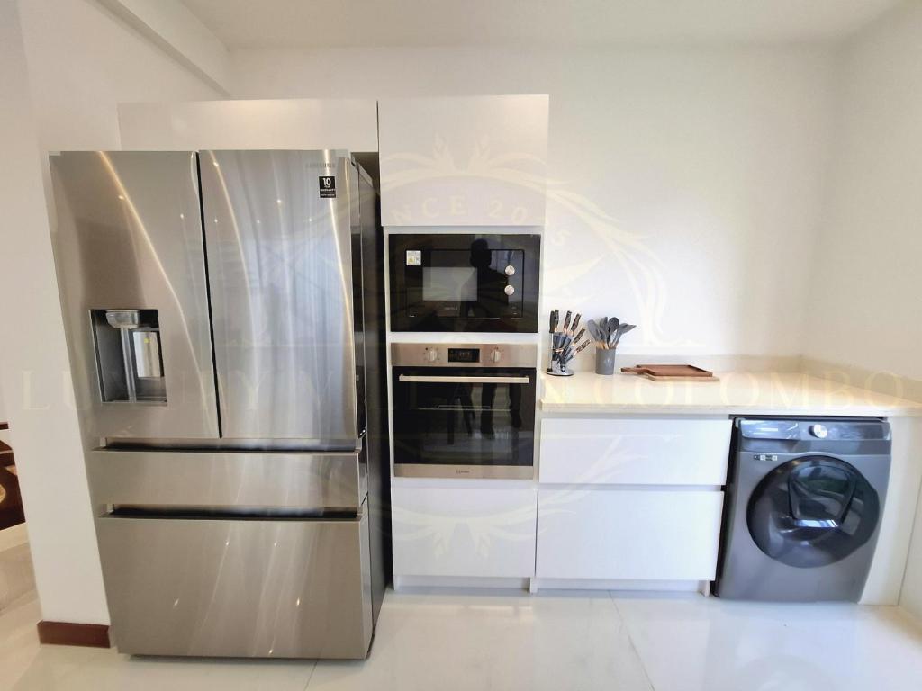 a kitchen with a stainless steel refrigerator and a dishwasher at Luxury Villa in Colombo in Rajagiriya