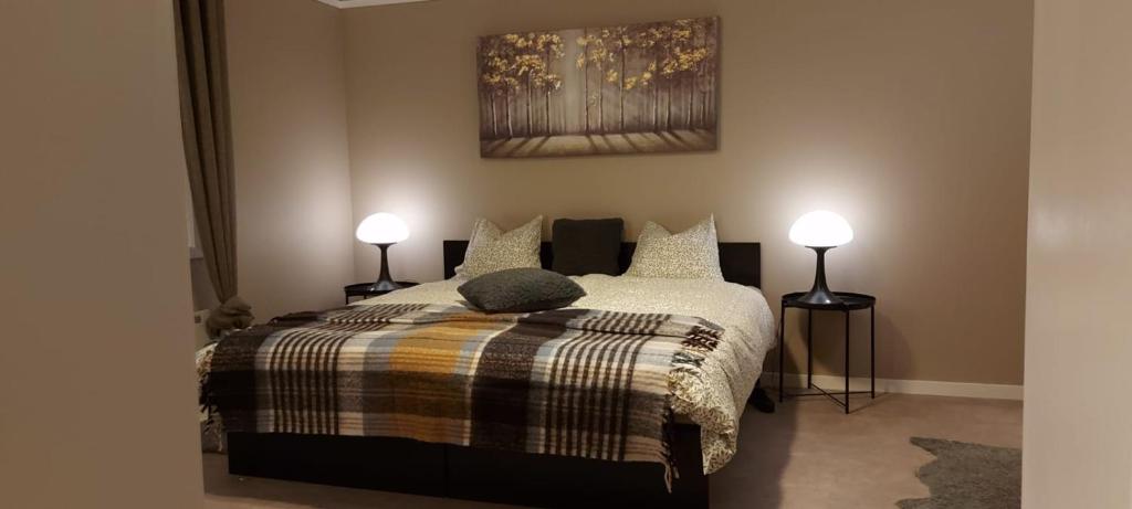 a bedroom with a bed with two lamps on it at The Cloudberry Hostel in Näsåker