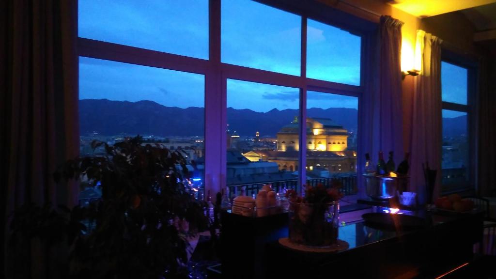 una ventana con vistas a la ciudad por la noche en Hotel Libertà, en Palermo