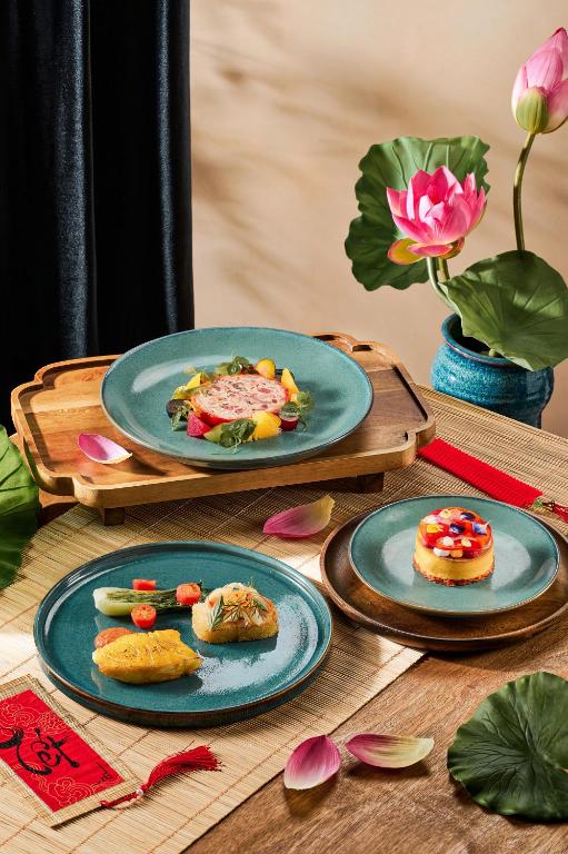A styled presentation of plated dishes and desserts on a wooden table.