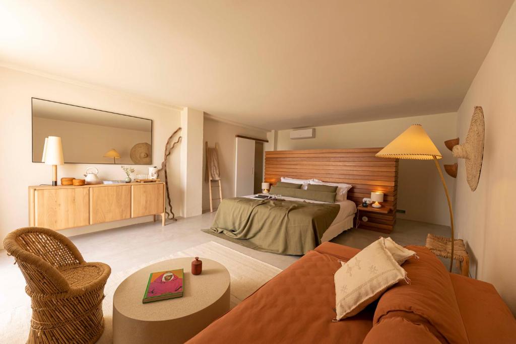 a hotel room with a bed and a couch at Boutique Hotel Jardines de Palerm in San Jose