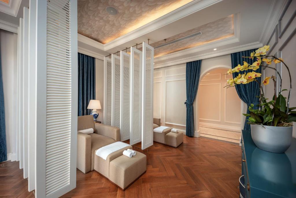 An elegant sitting room combines lounge chairs, screens, curtains, and orchids.