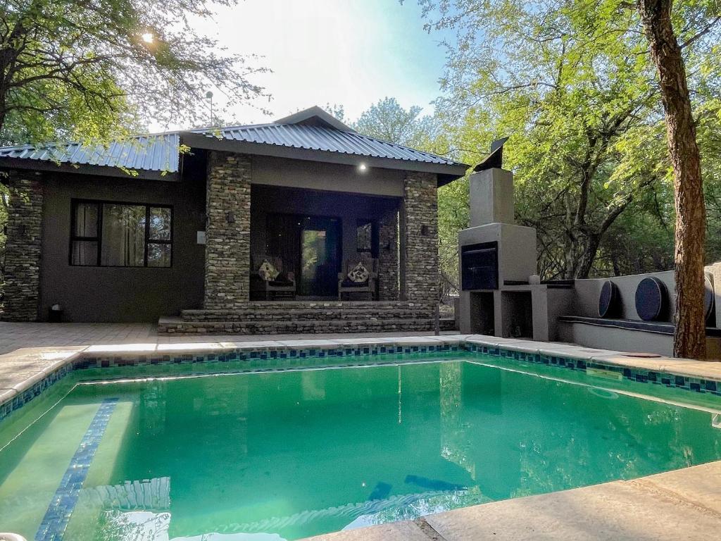ein Swimmingpool vor einem Haus in der Unterkunft The Porcupine Porch in Marloth Park