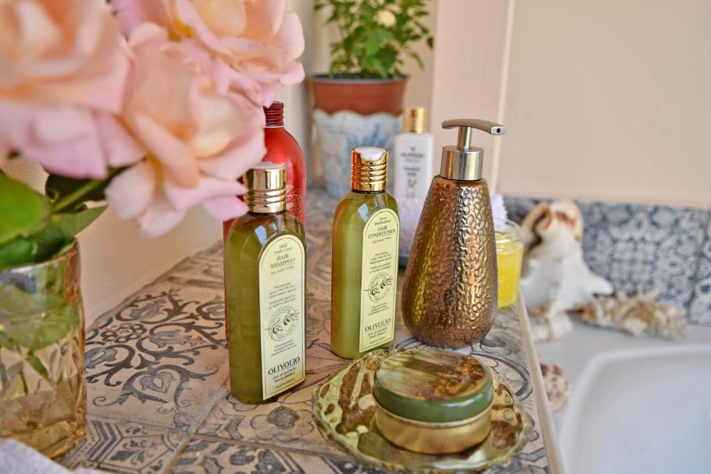 einen Tisch mit drei Flaschen Seife und einem Waschbecken in der Unterkunft Holiday Oasis with Private Magnesium Mineral Pool, Hammam-style Bath, Mini Golf in Chóra