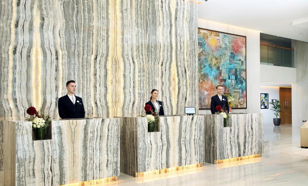 Členové personálu v ubytování Grand Cosmopolitan Hotel