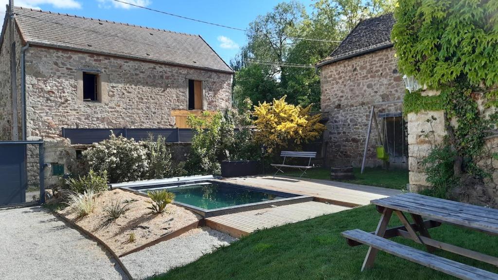 un jardin avec une piscine à côté d'un bâtiment dans l'établissement Charm'en Maranges, à Sampigny-lès-Maranges
