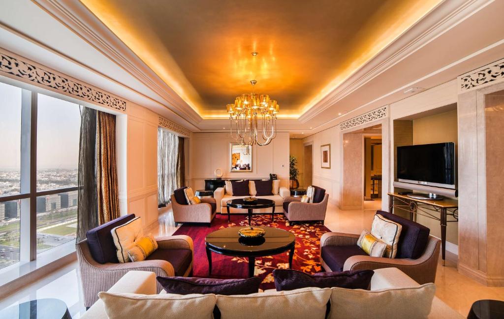 a living room with couches and a tv at Dusit Thani Abu Dhabi in Abu Dhabi