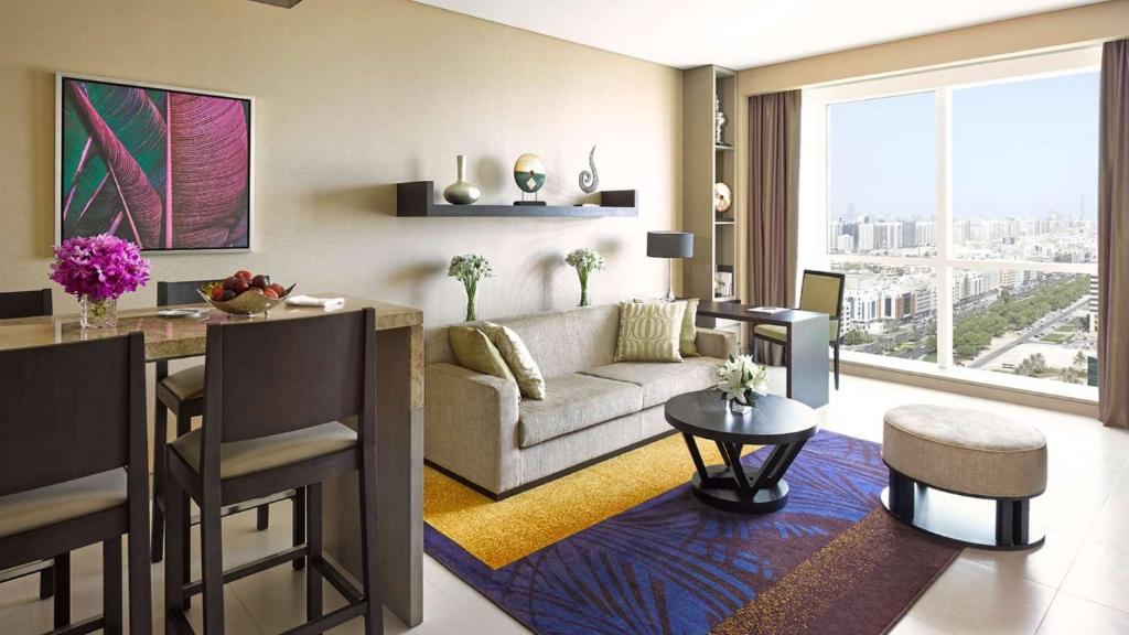 a living room with a couch and a table at Dusit Thani Abu Dhabi in Abu Dhabi