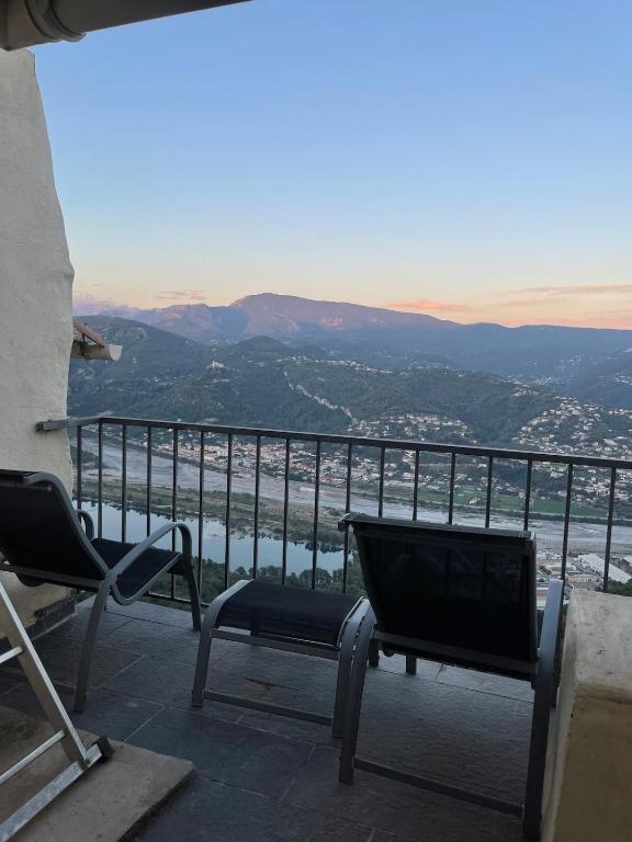d'un balcon avec des chaises et une vue sur la vallée. dans l'établissement Charmant duplex vue sur montagne, à Le Broc