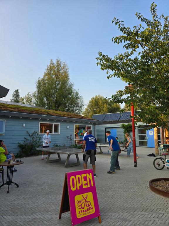 a group of people playing ping pong in a park at Camping Zeeburg Amsterdam in Amsterdam