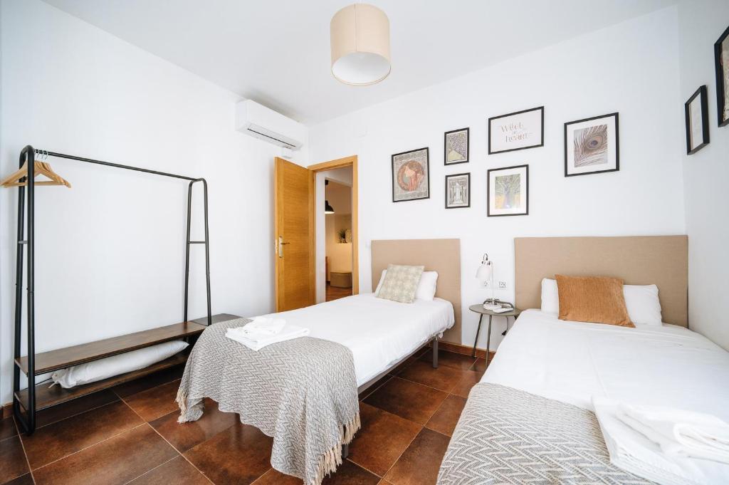 A bed or beds in a room at HomeySeville-Lovely Duplex at Santa Cruz 10 pax, Parking Optional