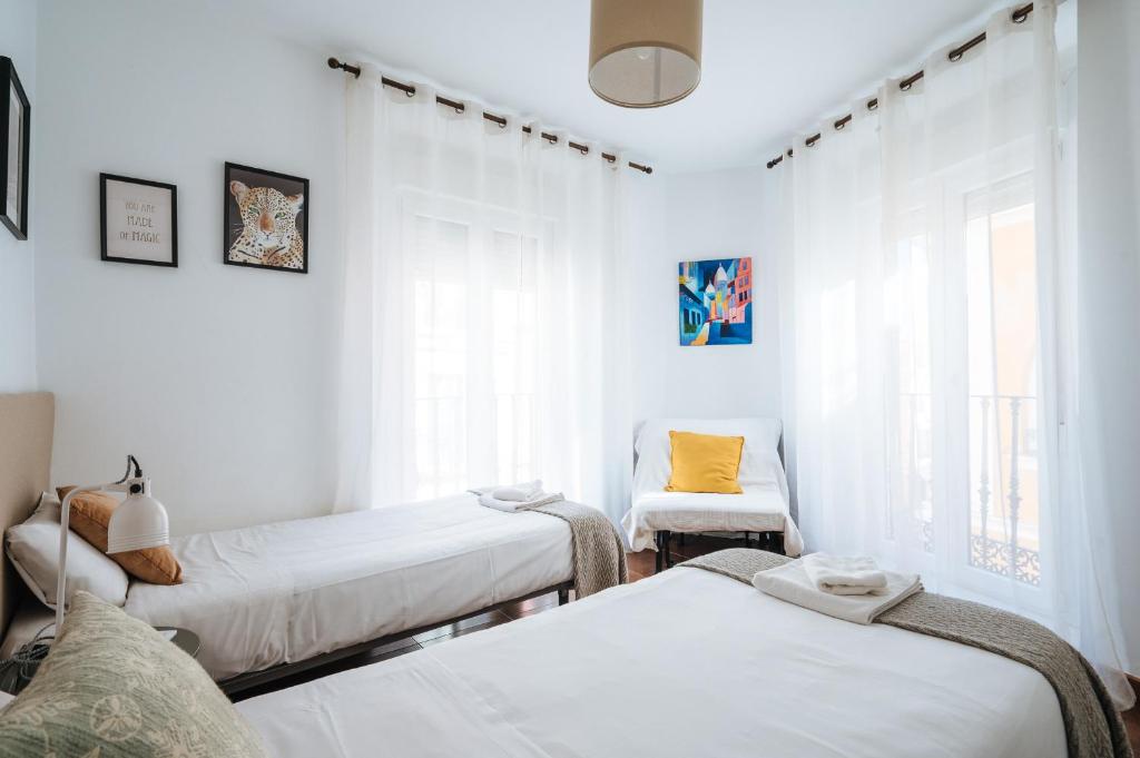 A bed or beds in a room at HomeySeville-Lovely Duplex at Santa Cruz 10 pax, Parking Optional