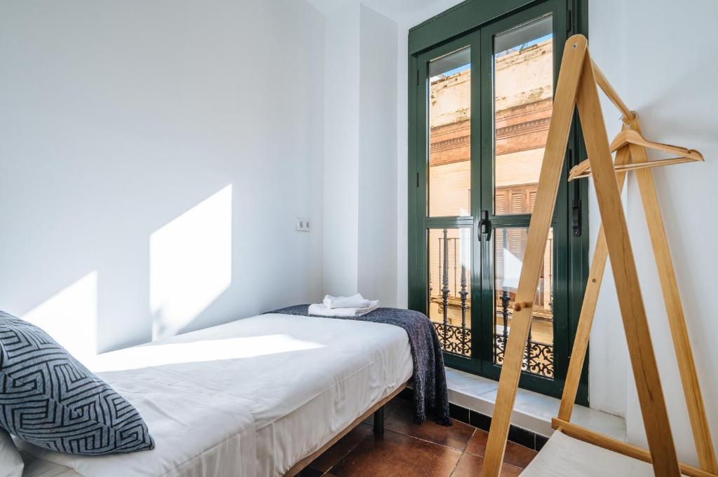 A bed or beds in a room at HomeySeville-Lovely Duplex at Santa Cruz 10 pax, Parking Optional