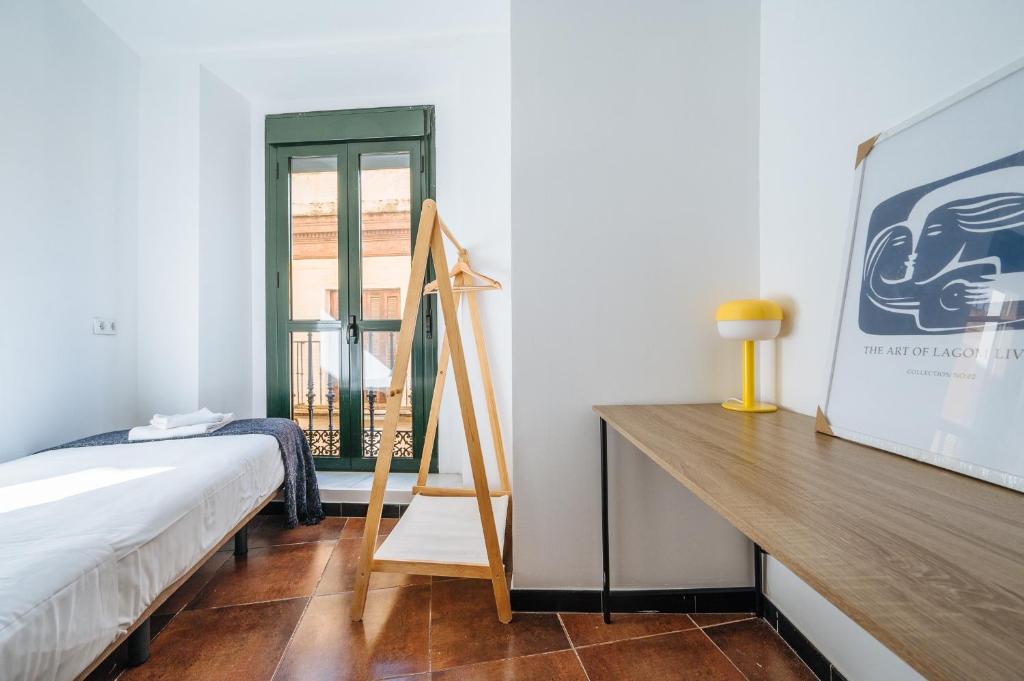 A bed or beds in a room at HomeySeville-Lovely Duplex at Santa Cruz 10 pax, Parking Optional