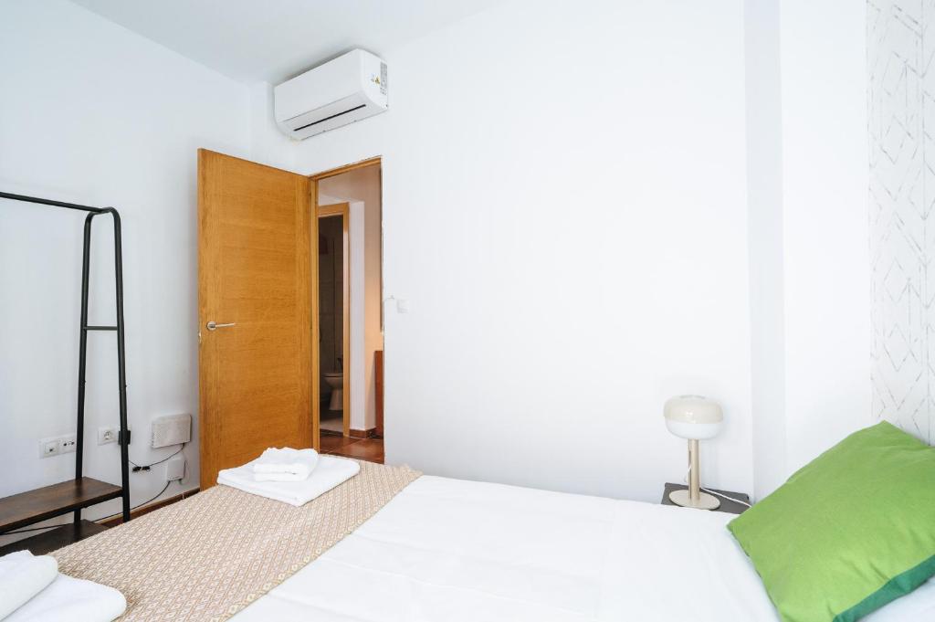 A bed or beds in a room at HomeySeville-Lovely Duplex at Santa Cruz 10 pax, Parking Optional