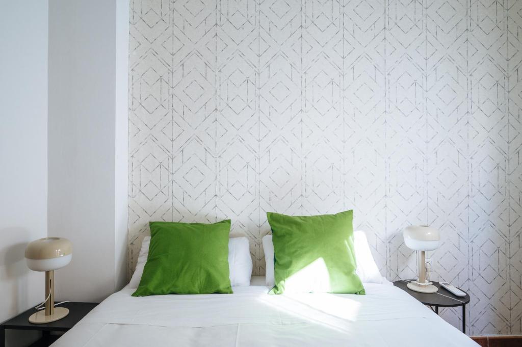 A bed or beds in a room at HomeySeville-Lovely Duplex at Santa Cruz 10 pax, Parking Optional