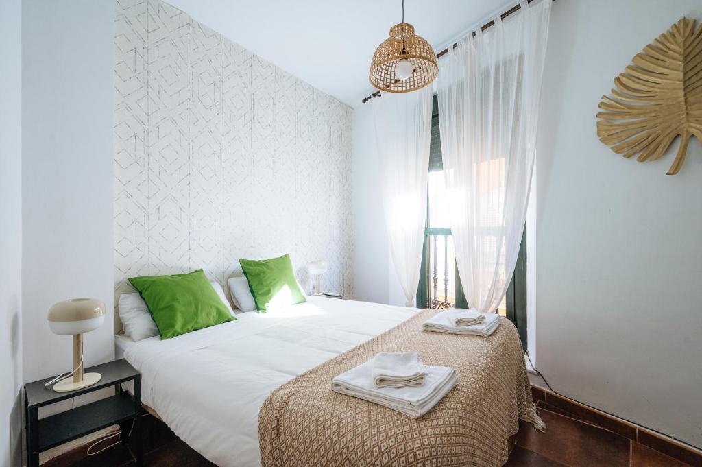 A bed or beds in a room at HomeySeville-Lovely Duplex at Santa Cruz 10 pax, Parking Optional