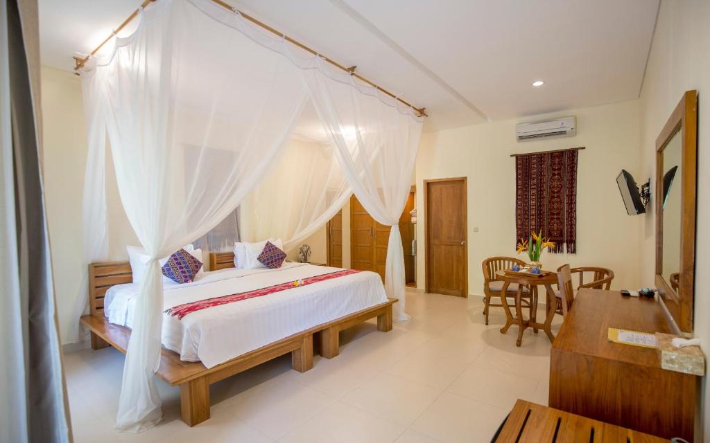 Postel nebo postele na pokoji v ubytování Puri Sari Beach Hotel