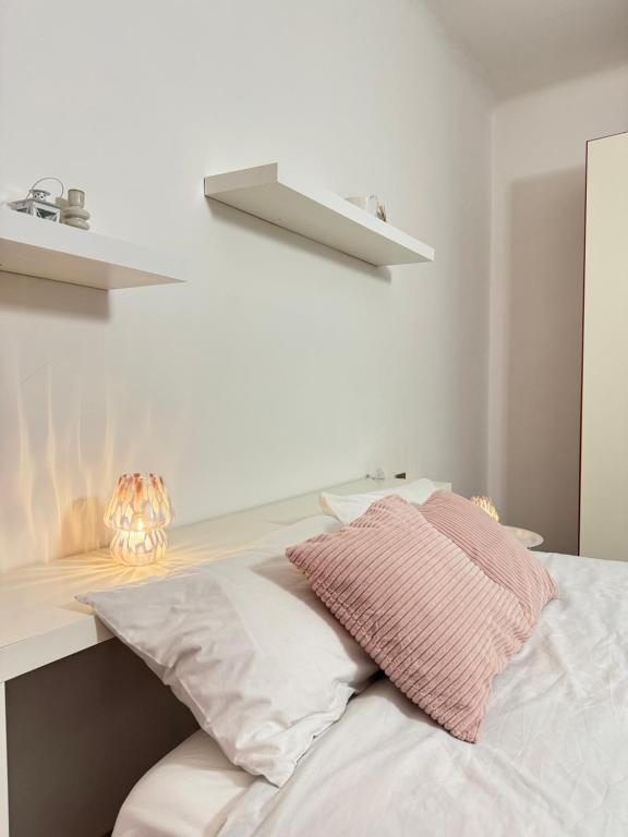 una cama con dos almohadas encima en Navigli Home Metro4-Tram2-Naviglio Grande, en Milán