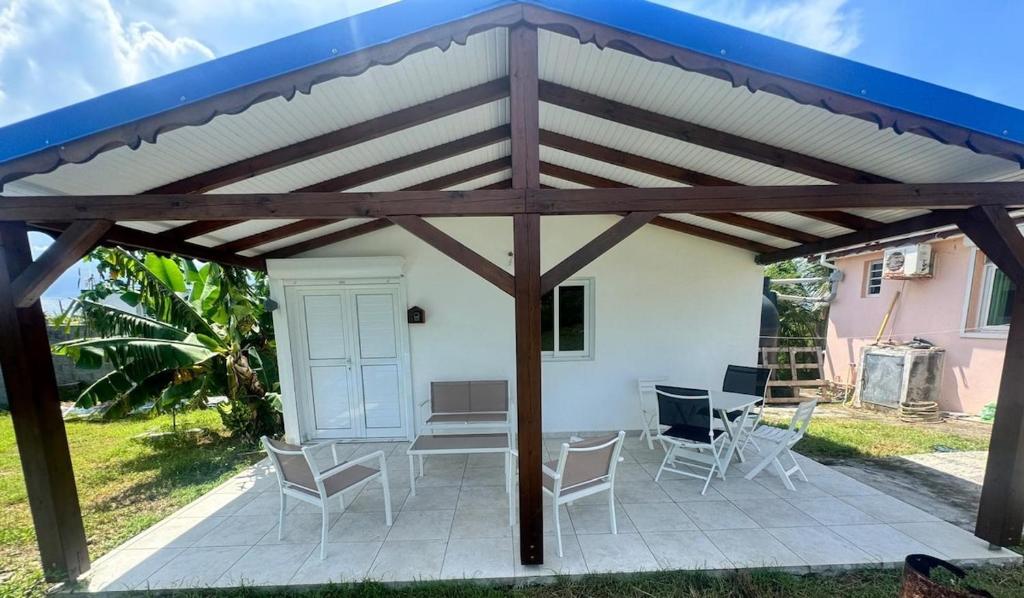 a pavilion with chairs and a table on a patio at Bien venu Miss' K in Anse-Bertrand