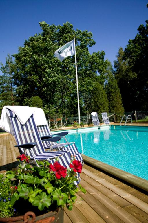 a couple of chairs sitting next to a swimming pool at Tallhöjden hotel & Restaurant in Simlångsdalen