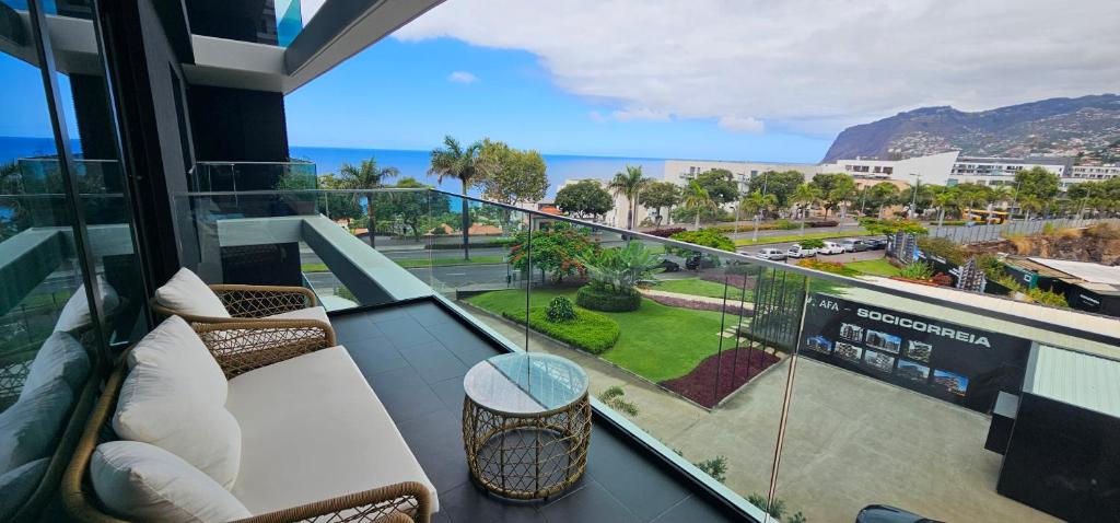 a balcony with chairs and a view of the ocean at LUX OCEAN VIEW Apartment Varino 05 in Funchal