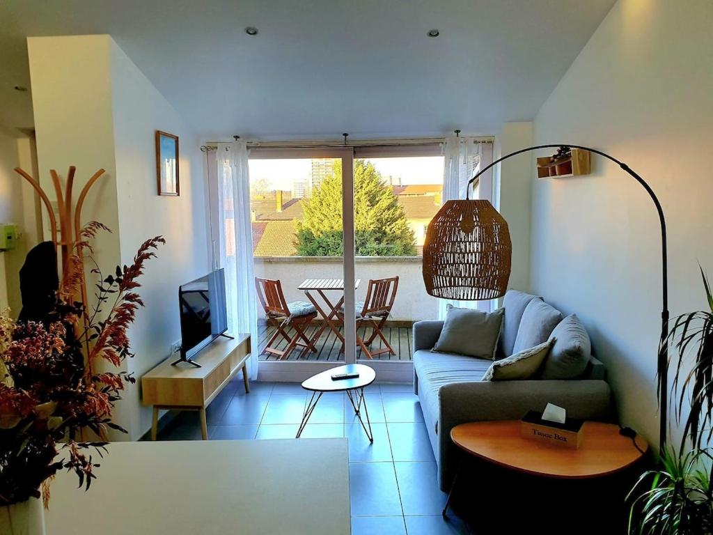 ロアンヌにあるL'Or du temps, appartement cosyのソファとテーブルのあるリビングルーム