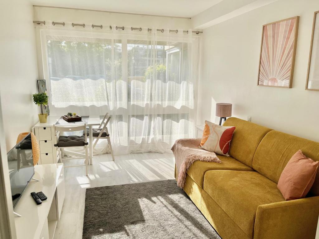 ein Wohnzimmer mit Sofa und Tisch in der Unterkunft HanaHome 2 adultes parking privé business & tourisme in Le Chesnay