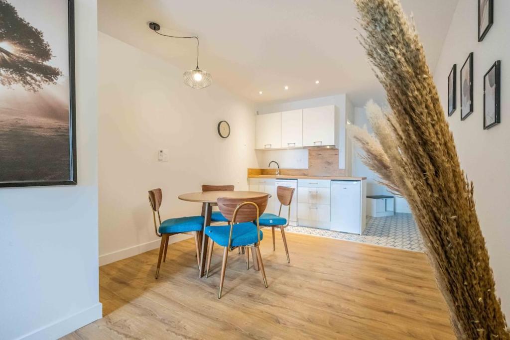 une cuisine et une salle à manger avec une table et des chaises dans l'établissement L'Hippocrate Duplex à deux pas des Halles, à Narbonne