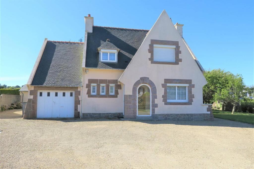 a large house with a driveway in front of it at Maison à 500m de la mer et à 100m des commerces à TREGASTEL - Réf 20 in Trégastel