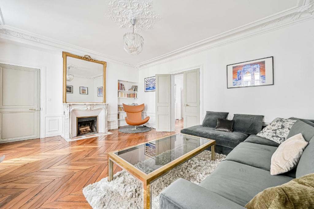 un salon avec un canapé et une cheminée dans l'établissement Appartement de luxe - Assemblée Nationale, à Paris